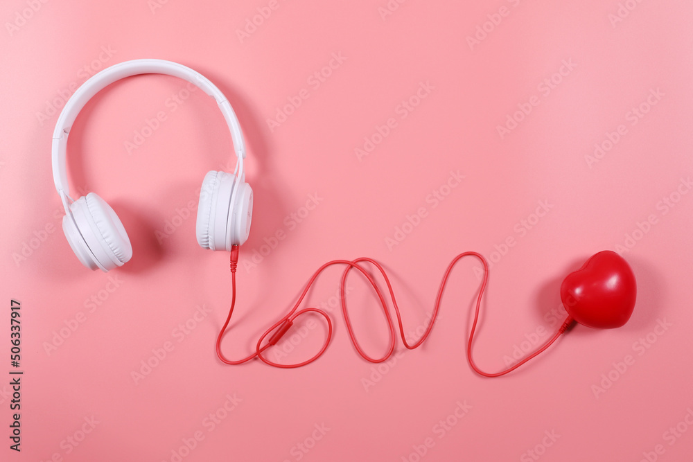 White headphone with red heart isolated on pink background, flat lay photography have copy space. White headphone with red heart isolated on pink background, flat lay photography have copy space.