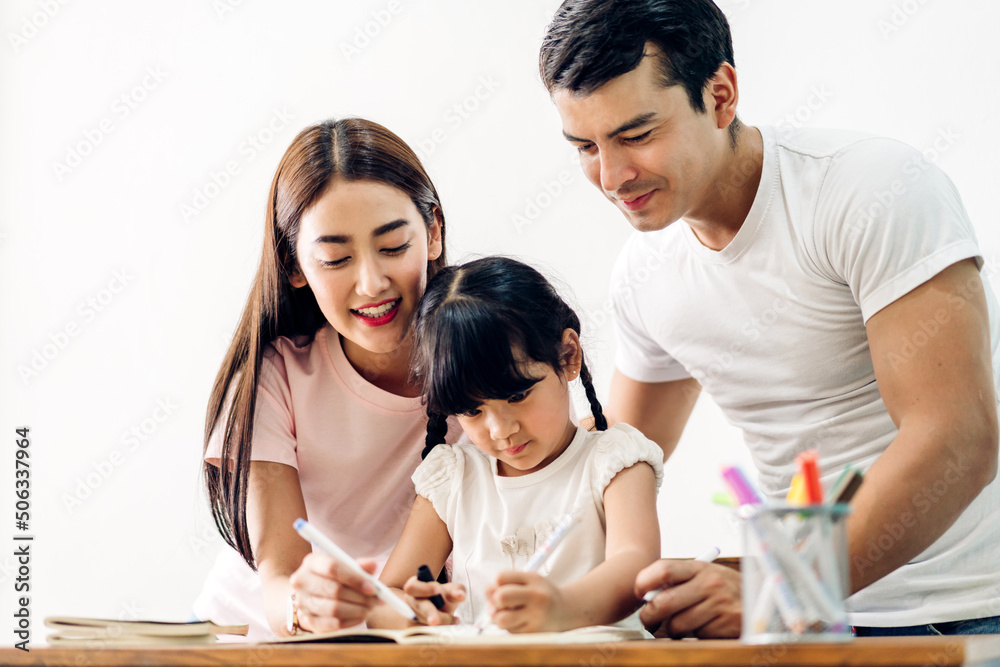 Portrait happy love asian family father and mother with little asian girl learn and study on table.Mom and dad with asian young girl writing with book make homework in homeschool at home.Education Portrait happy love asian family father and mother with little asian girl learn and study on table.Mom and dad with asian young girl writing with book make homework in homeschool at home.Education