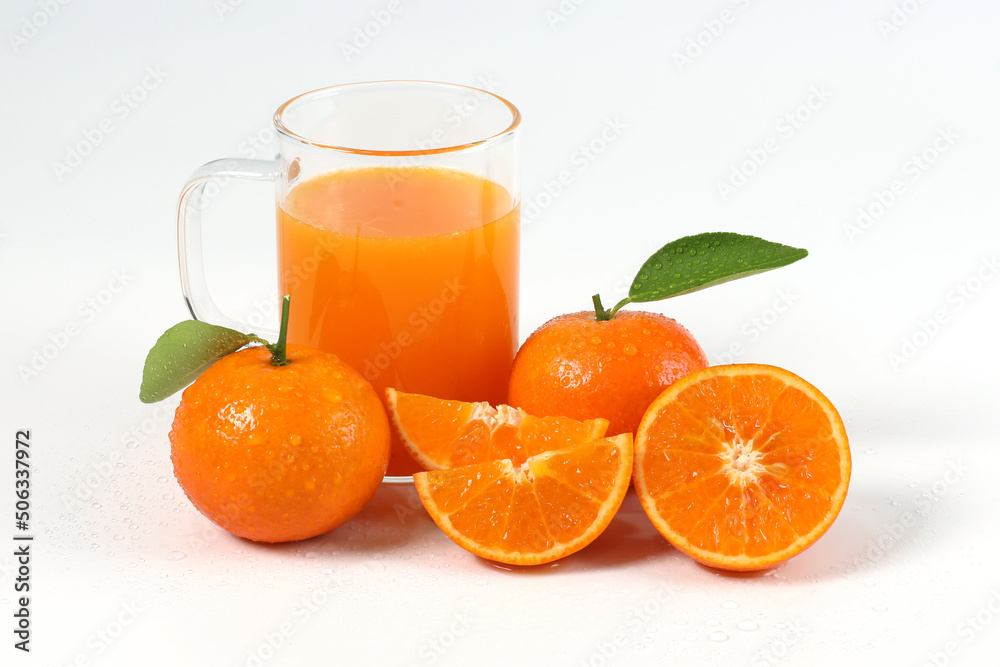 Orange, halved oranges squeezed into juice in clear glass, healthy fruit, mandarin oranges, vitamin C, white background with refreshing drop of water Orange, halved oranges squeezed into juice in clear glass, healthy fruit, mandarin oranges, vitamin C, white background with refreshing drop of water