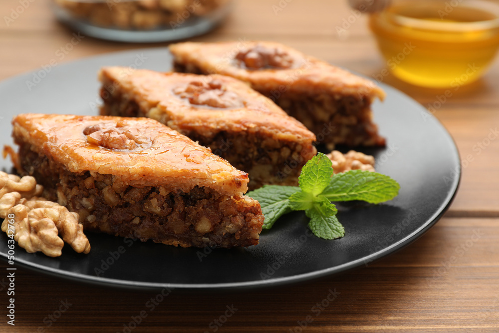 Delicious honey baklava with walnuts on wooden table, closeup