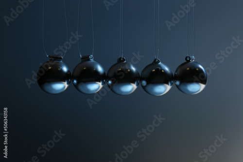 Newton's cradle on grey background, closeup. Physics law of energy conservation