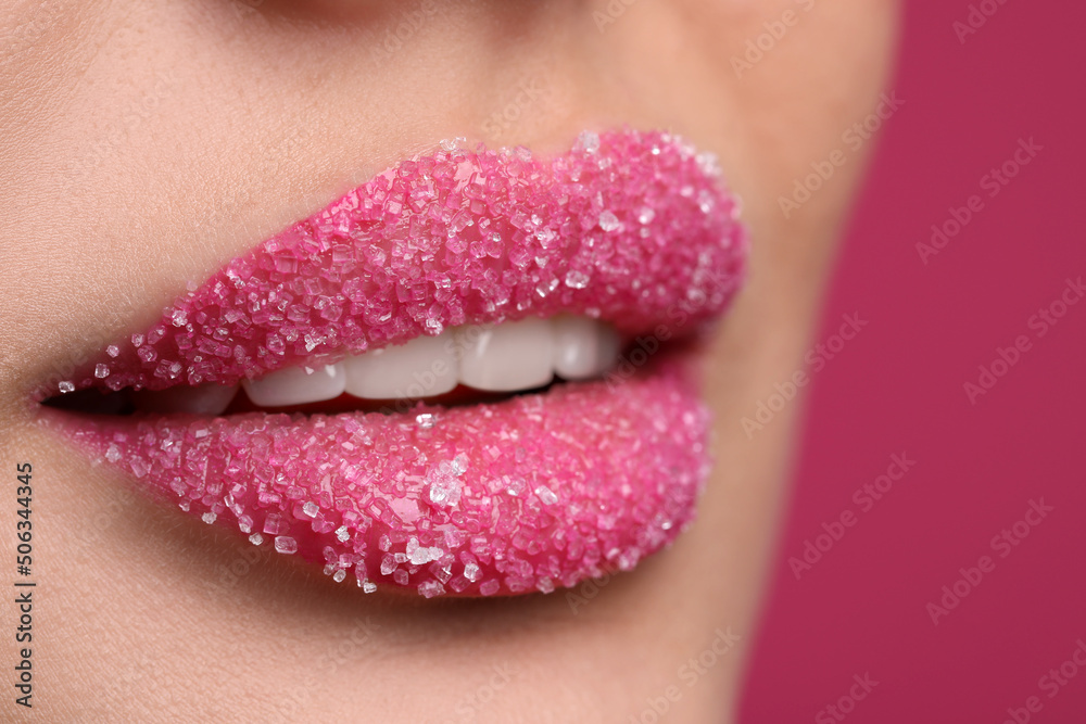 Young woman with beautiful lips covered in sugar, on pink background, closeup Young woman with beautiful lips covered in sugar, on pink background, closeup