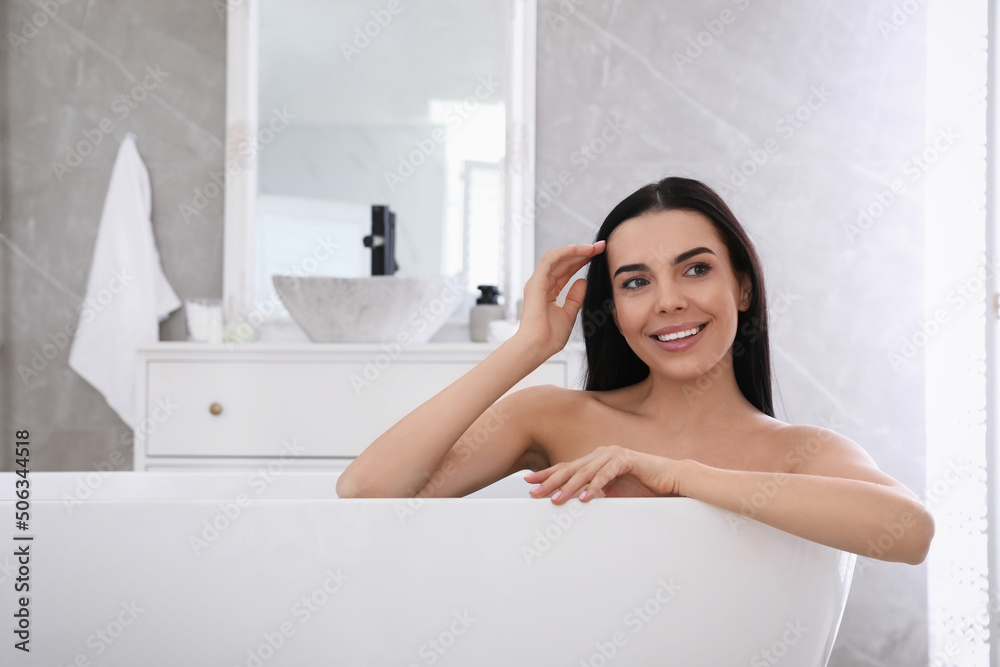 Obraz premium Beautiful young woman relaxing in bathtub at home