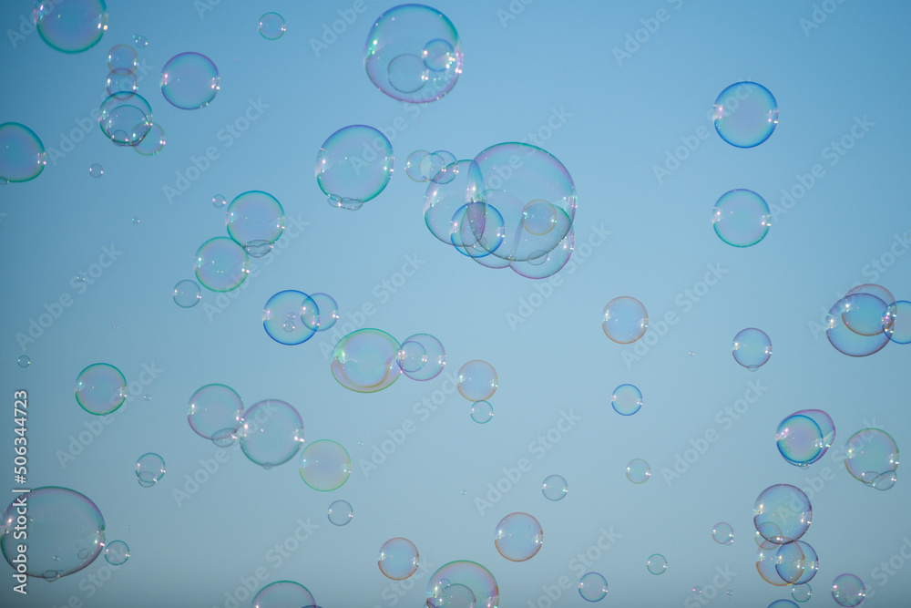 Many big soap bubbles. Colorful soap bubble on the blue sky.