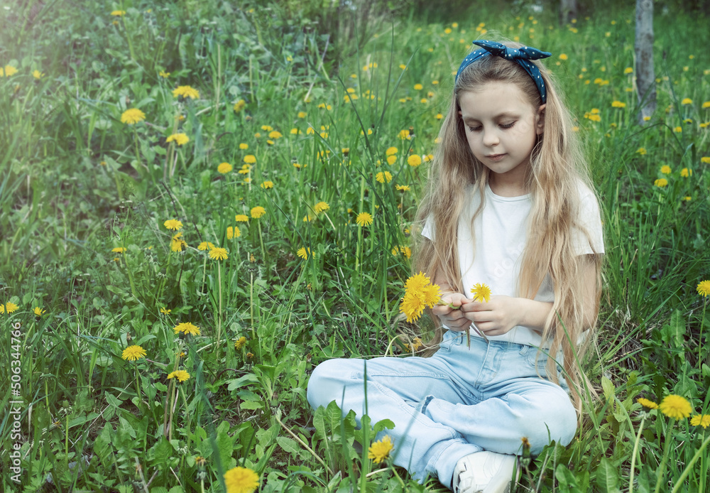 Image of pretty little girl sitting on dandelions field Image of pretty little girl sitting on dandelions field