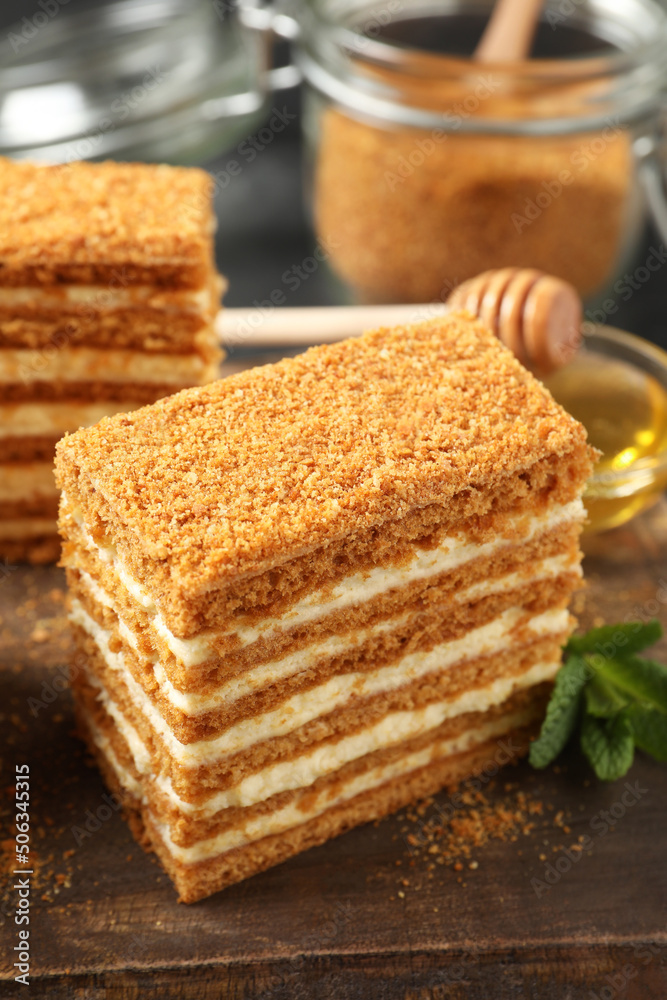 Delicious layered honey cake on wooden board, closeup Delicious layered honey cake on wooden board, closeup