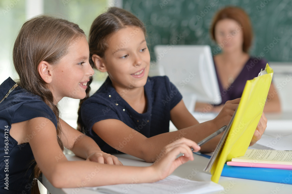 Beautiful girls studying at the desk in class room Beautiful girls studying at the desk in class room