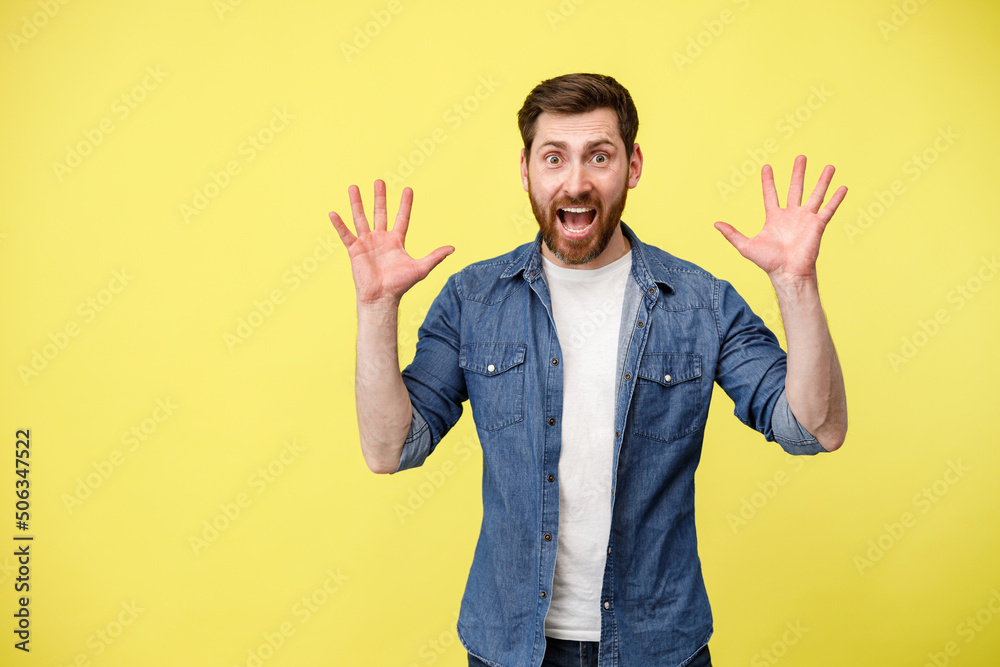 Scared man with raised his hands up and shouting sees something in front Scared man with raised his hands up and shouting sees something in front
