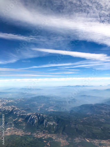 A beautiful view from the airplane window to the skies, mountains and plains © shine.graphics