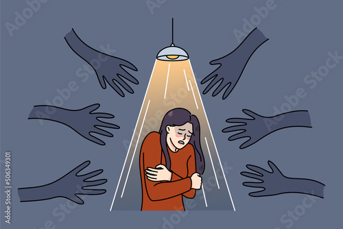 Terrified woman stand under spotlight haunted by numerous black hands. Unhappy scared girl suffer from psychological problems, have fears and anxiety. Vector illustration. 