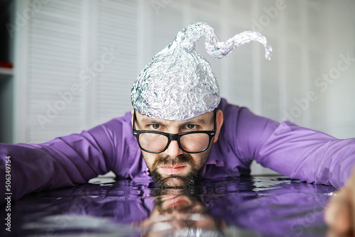 Vászonkép Bearded funny man in a cap of aluminum foil