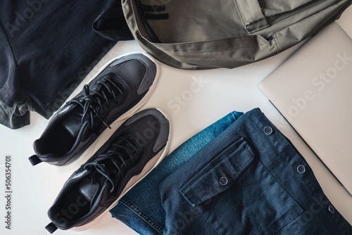 Set of men's things, flat lay top view. Sneakers, backpack, jeans and jacket on a white background