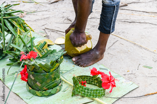 Young man peeling coconut fruit at the farm at Zanzibar island
