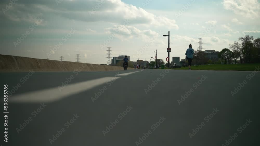Low angle of a bike path as a cyclist rides by. Slow motion. Low angle of a bike path as a cyclist rides by. Slow motion.