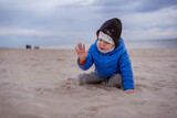 Child, toddler, little boy playing in the sandy Baltic sea beach. Family vacation and lifestyle concept.