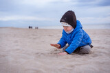Child, toddler, little boy playing in the sandy Baltic sea beach. Family vacation and lifestyle concept.