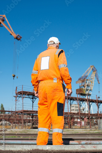 Canvas Print Shipyard worker in overalls, rear view