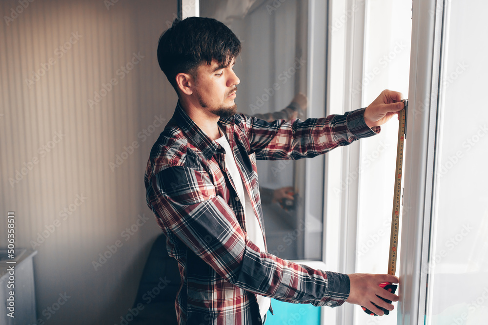 construction worker measuring window with construction tape measure construction worker measuring window with construction tape measure