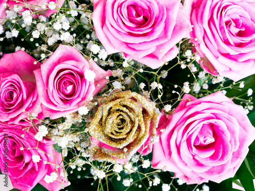 Bright pink and golden roses flower bouquet top view close up, natural festive pattern