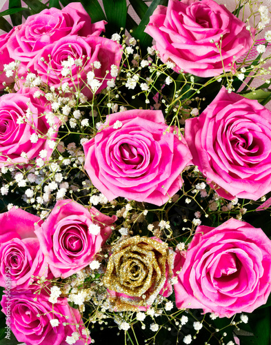 Bright pink and golden roses flower bouquet top view close up, floral background