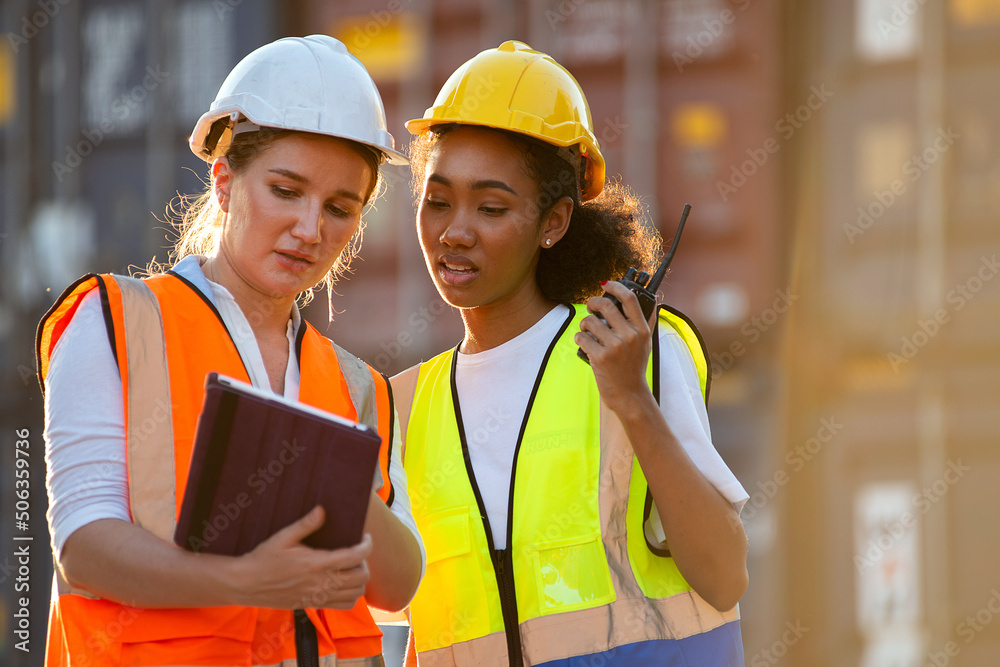 Businesswoman and logistics woman worker checking containers box and loading products in computer from Cargo freight ship at Cargo container. Businesswoman and logistics woman worker checking containers box and loading products in computer from Cargo freight ship at Cargo container.