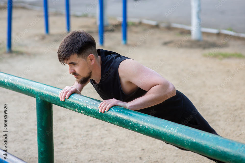 Fototapeta premium Male athlete doing push-ups on the sports ground, close-up