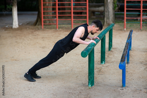 Male athlete doing push-ups on the sports ground