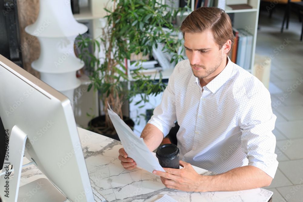 Successful entrepreneur is studying documents with attentive and concentrated look. Successful entrepreneur is studying documents with attentive and concentrated look.