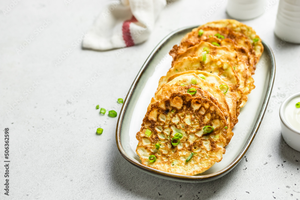 Zucchini fritters with sour cream. Top view, copy space, flat lay.