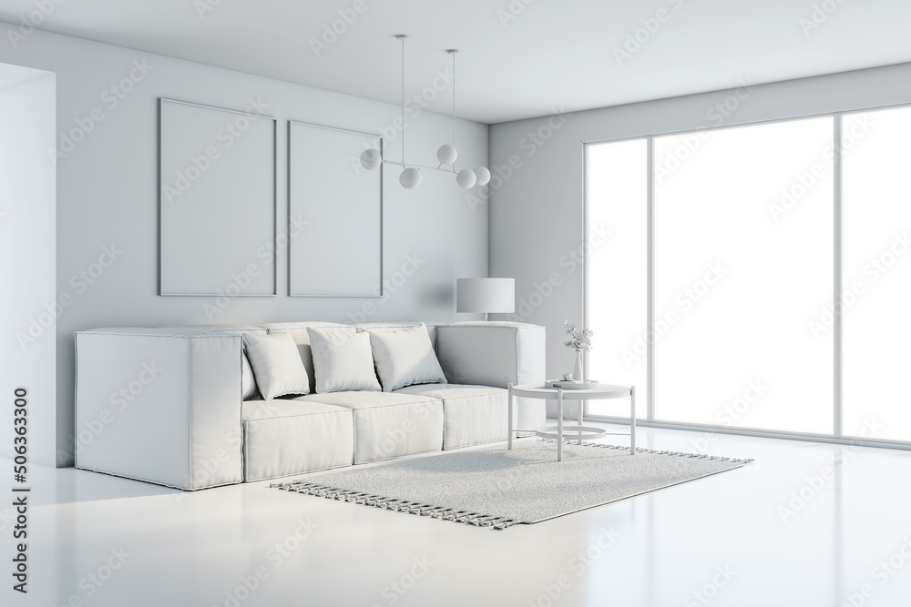 Side view on all-white interior design in sunny modern living room with comfortable sofa, carpet and coffee table on glossy floor, empty frame pictures on the wall and big window. 3D rendering Side view on all-white interior design in sunny modern living room with comfortable sofa, carpet and coffee table on glossy floor, empty frame pictures on the wall and big window. 3D rendering