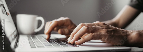 Man hands typing on computer keyboard closeup panoramic banner, businessman or student using laptop at home, online learning, internet marketing, working from home, office workplace, freelance concept