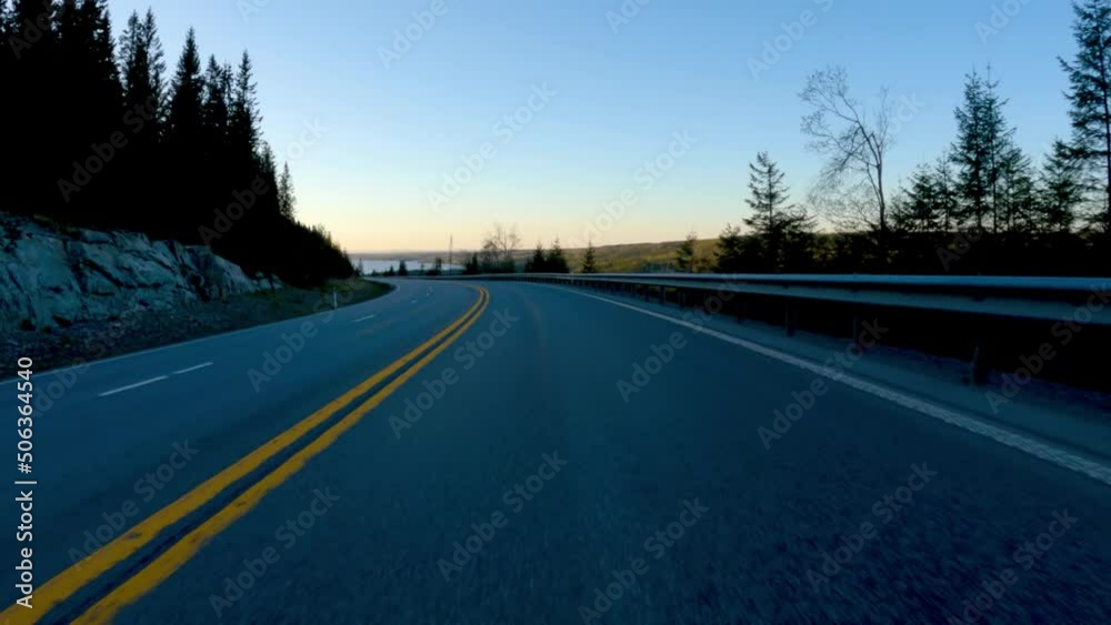 Driving down a mountain on a highway at night or dusk. Drivers point of view.