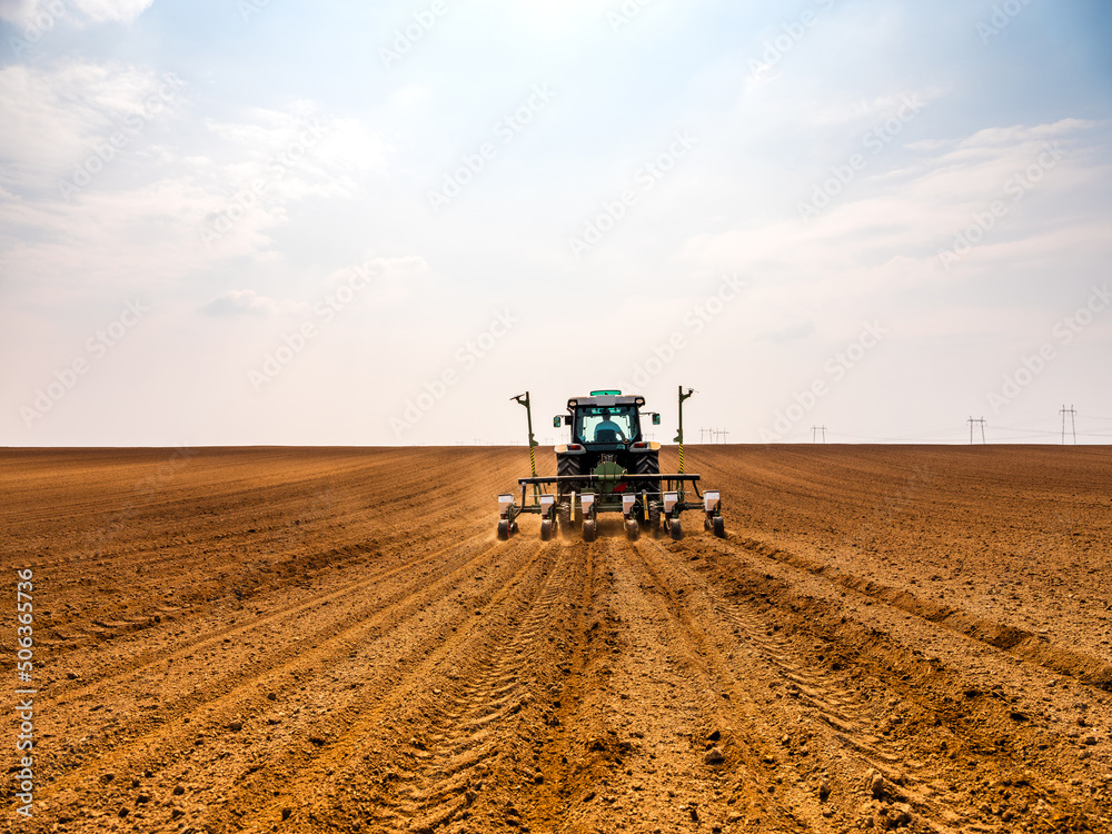 Fototapeta premium Tractor drilling seeding crops at farm field. Agricultural activity.