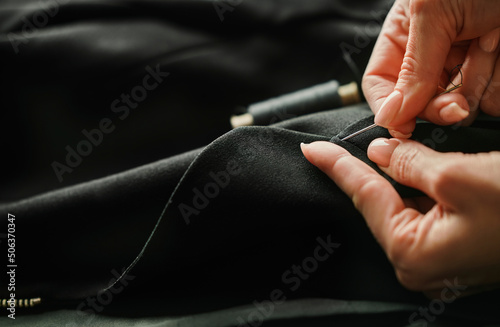 Hands of tailor finishing tailored suit photo