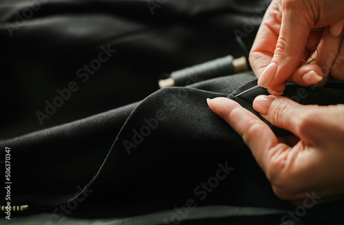 Hands of tailor finishing tailored suit