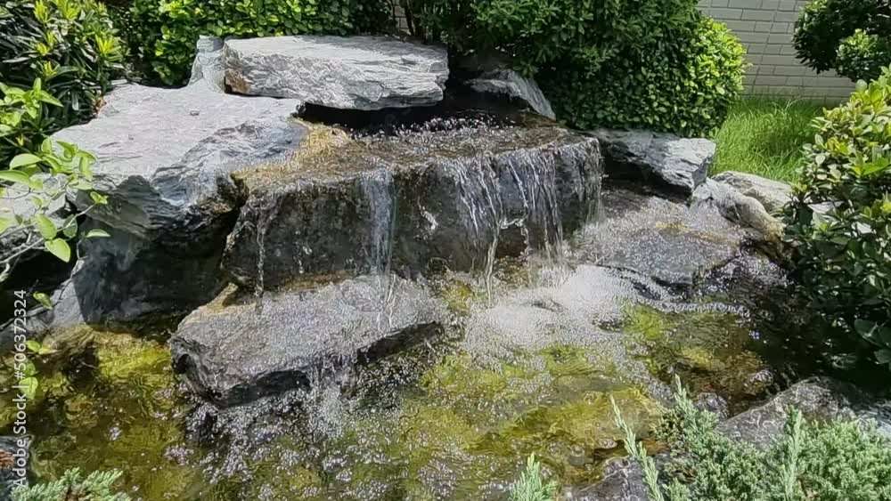 Artificial waterfall in a small garden with natural background