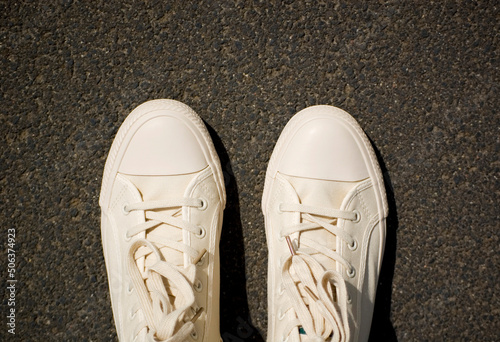 New white gym plimsolls on the pavement. photo