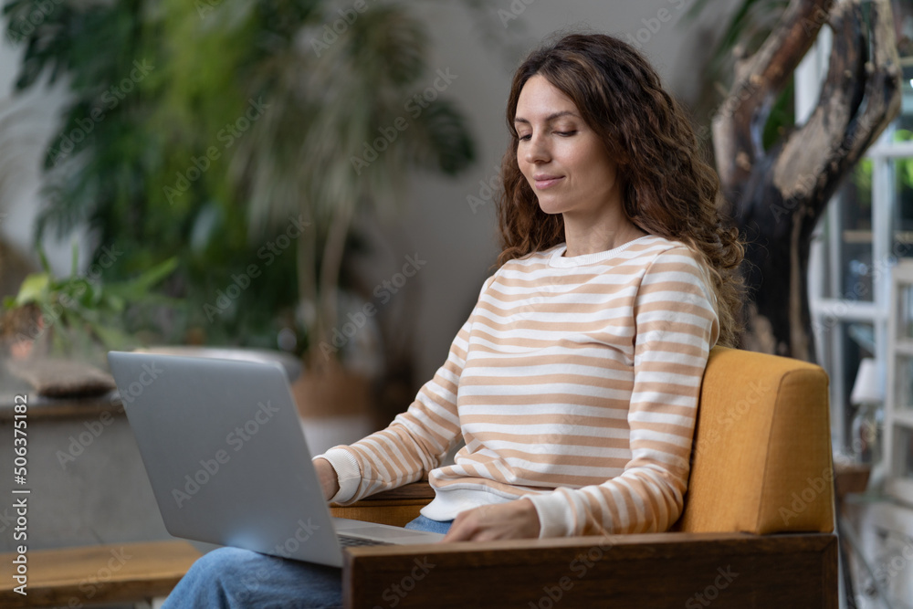 Positive lady freelancer smiling, sitting in cafe, project working, looking into screen of notebook computer. Beautiful young smiling student girl getting education. Enjoying time at modern coworking. Positive lady freelancer smiling, sitting in cafe, project working, looking into screen of notebook computer. Beautiful young smiling student girl getting education. Enjoying time at modern coworking.