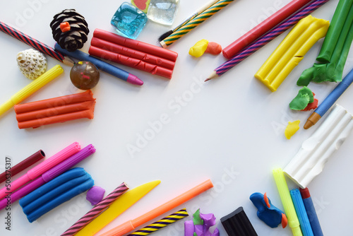 Colored markers and pencils, plasticine, notepad and white sheet, top view. Creative art kids layout with copyspace