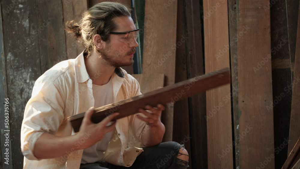 Carpenter checking accurate of wood at garage. Worker use measure on surface wood. Man checking the surface and calculation. Carpenter checking accurate of wood at garage. Worker use measure on surface wood. Man checking the surface and calculation.