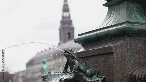 Stork fountain in Copenhagen Central square people walking in front of tower photo