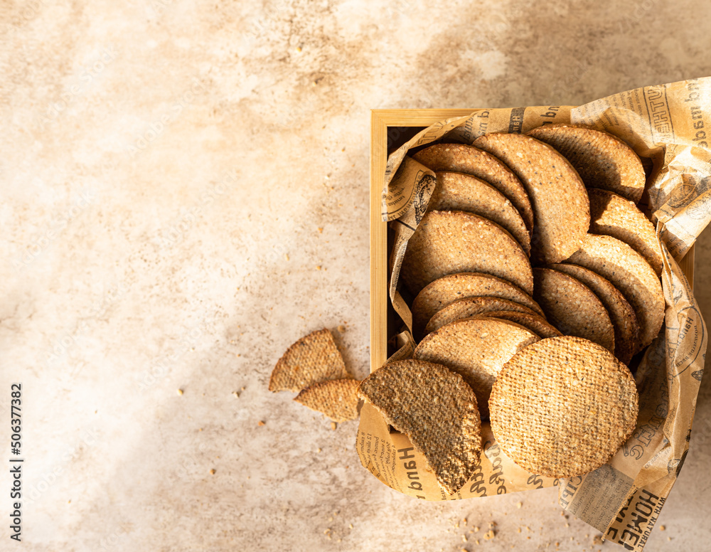 Delicious crackers with sesame and flax seeds on brown stone background. Healthy snack. Top view. Delicious crackers with sesame and flax seeds on brown stone background. Healthy snack. Top view.