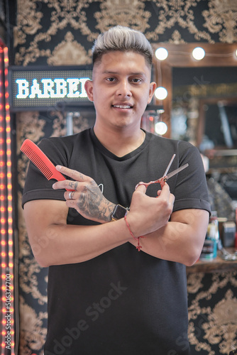 Young handsome man in barbershop having a haircut