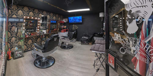 Empty black chairs and mirrors in barber shop