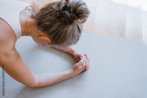 Cropped view of the senior beautiful athletic woman makes an exercise plank. Healthy lifestyle. A woman goes in for sports at home