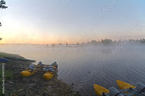 Tourist catamarans on the river bank in the morning mist.