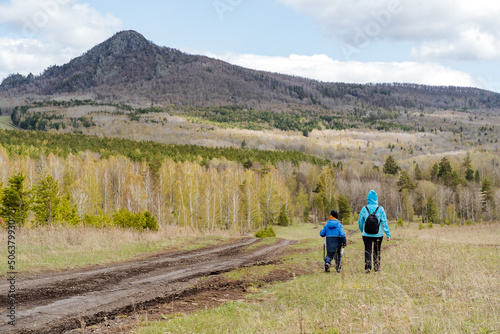 Mountain hiking with children, family trip to nature, hiking in the forest, mother takes her son on a hike, active lifestyle, summer vacations outside the city © Aleksey