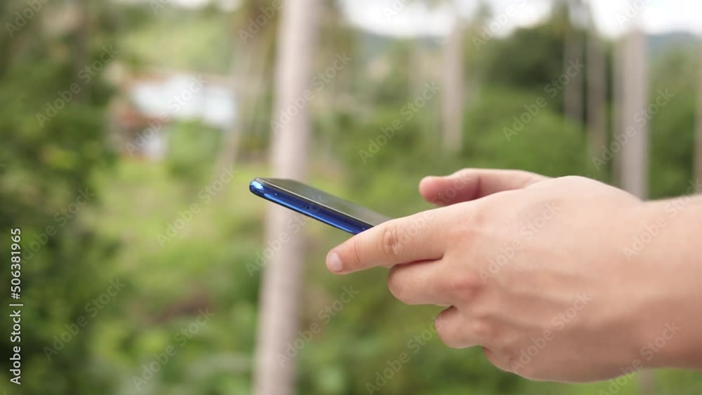 Male hands using google maps in a smart phone. Man holds phone in hands and uses gps while traveling in a tropical jungle. 3840x2160