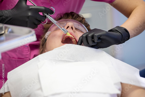doctor makes an injection in a sick tooth to a patient  modern dental technology