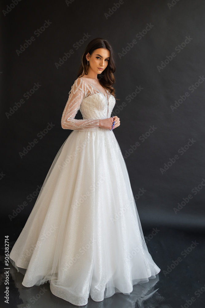 Beautiful bride in a magnificent white wedding dress of tulle with corset lacing and long beauty hair